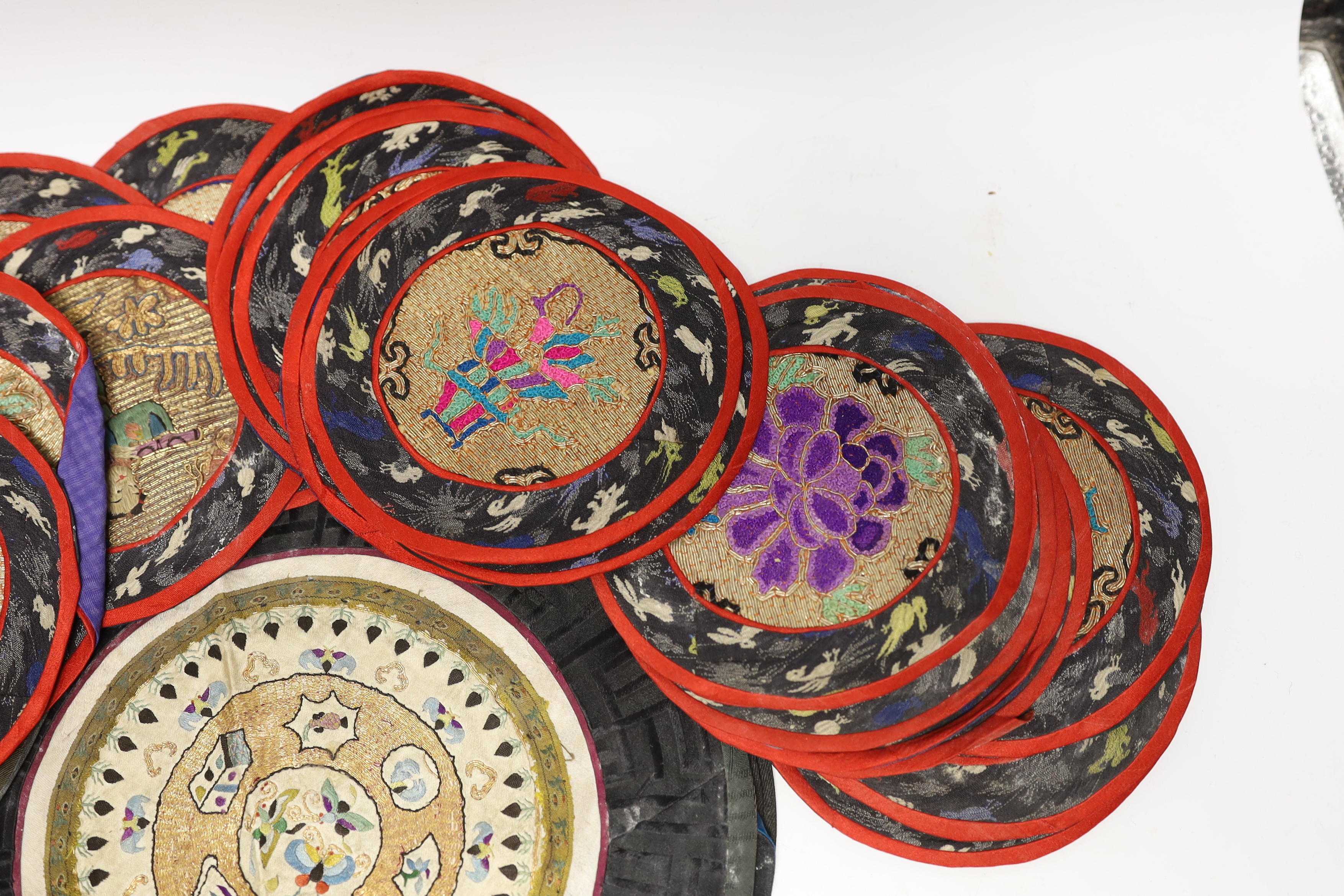Three sets of six circular Chinese polychrome and gilt thread embroidered mats, a set of four mats and seven other similar various sized embroidered mats, (29)